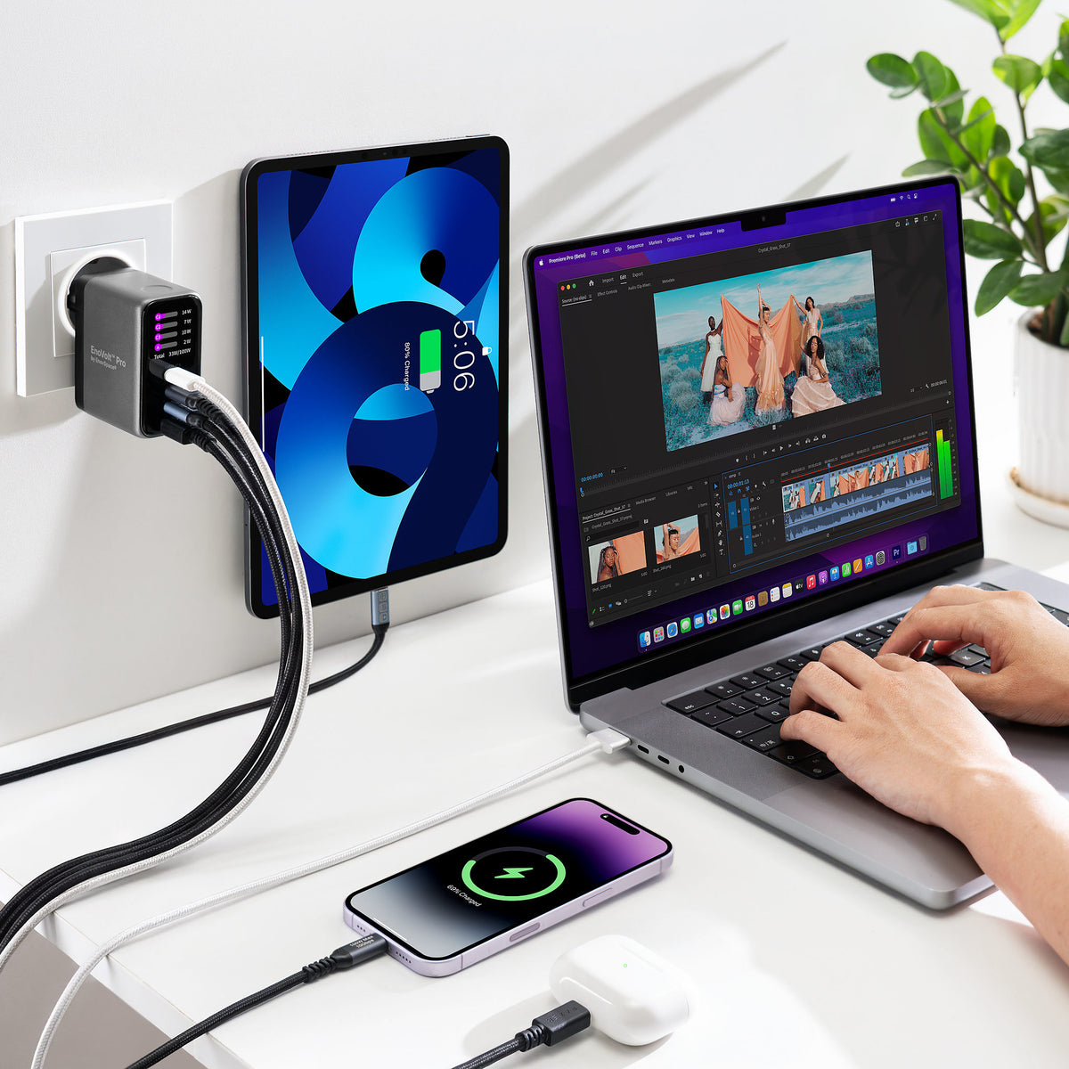 EnoVolt Pro 100W charging a laptop, a tablet and a phone at the same time on a desk