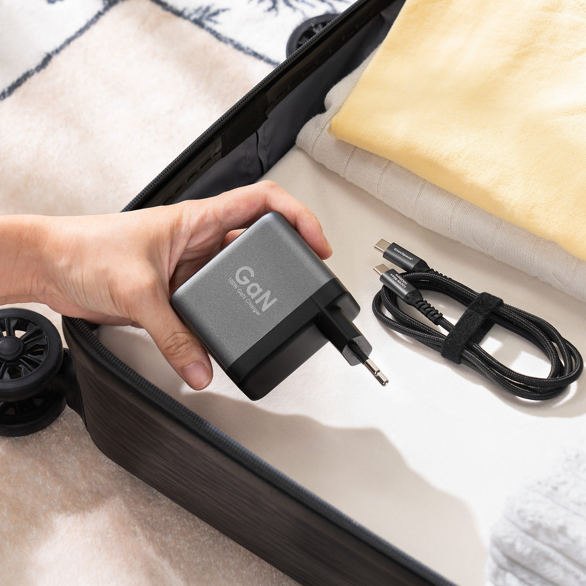 EnoVolt Pro 100W packed in a suitcase with its cable, ready to travel